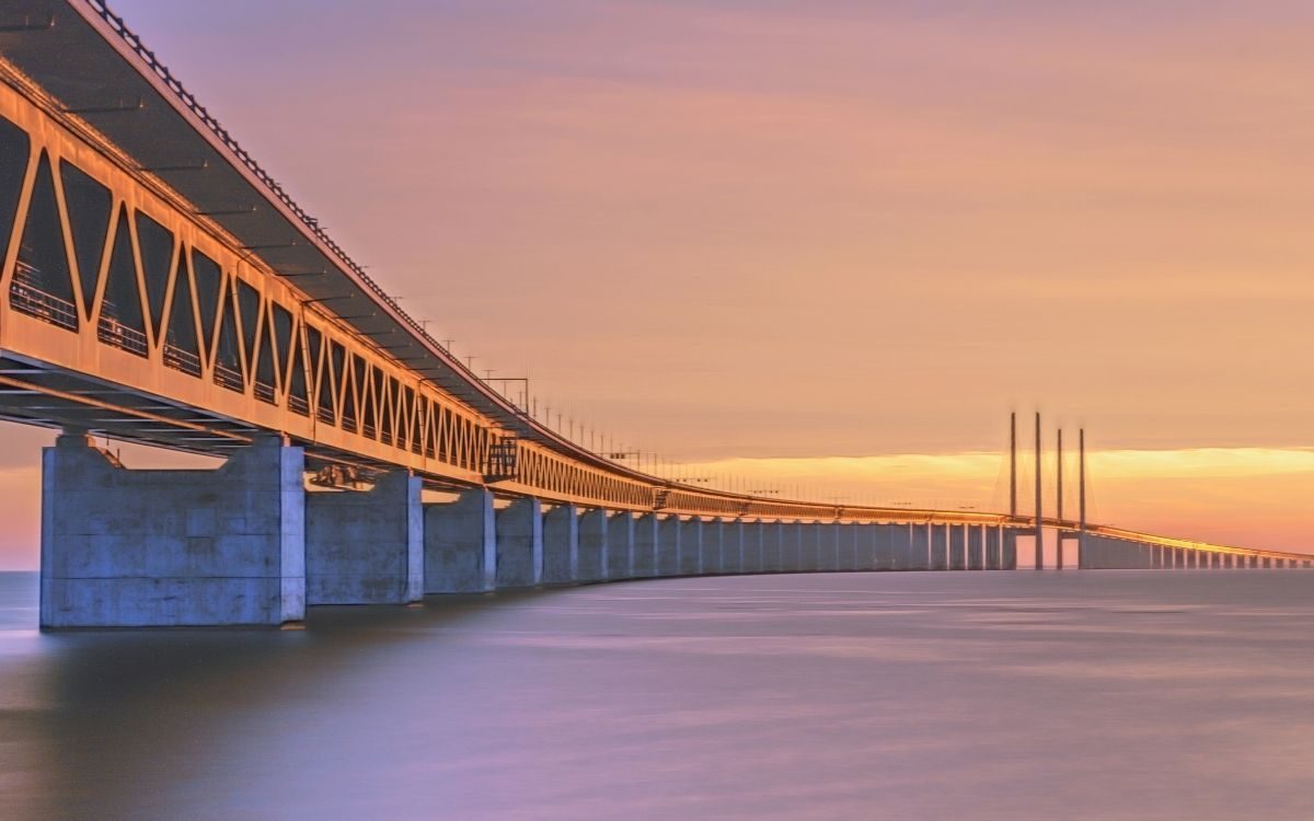 Sonnenuntergang hinter der Öresundbrücke mit den Pylonen am Horizont