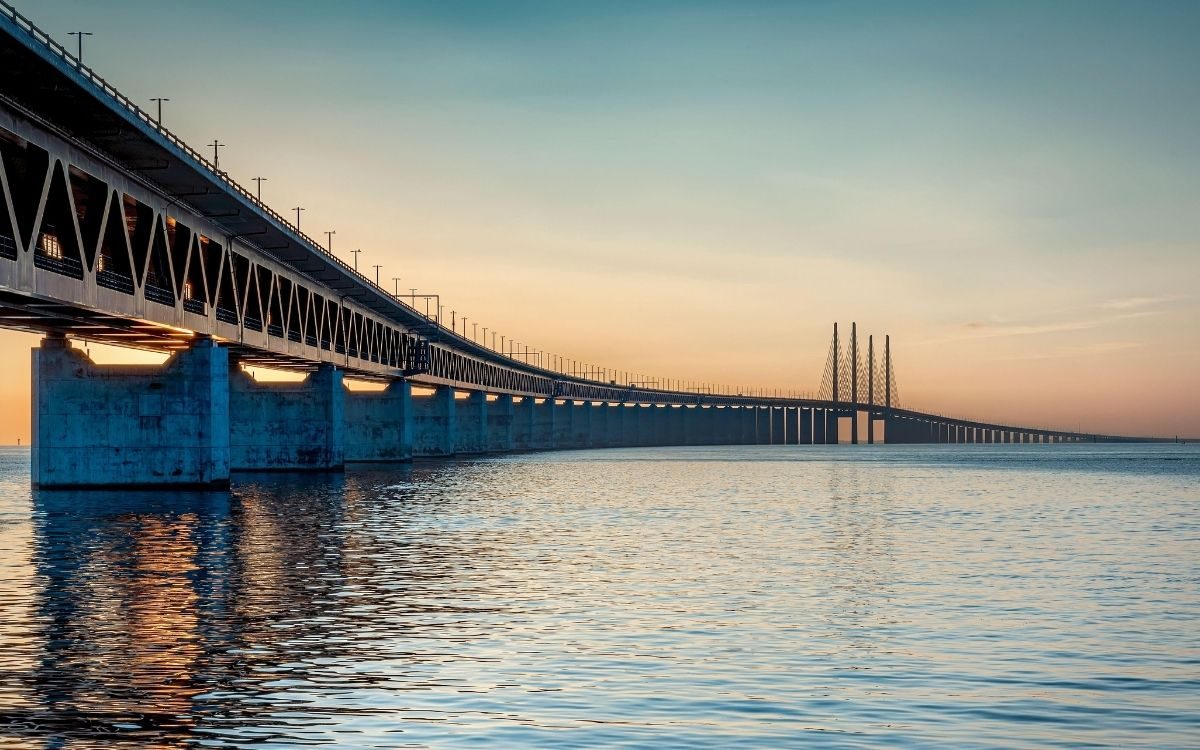 Die Öresundbrücke bei Sonnenuntergang vom Wasser aus, mit dem Bahndeck unter der Fahrbahn